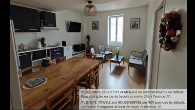 a kitchen and living room with a wooden table and chairs at Appartements simples et fonctionnels in Pamiers