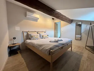 a bedroom with a large bed in a room at Hidden Oasis - Maison de caractère avec piscine in Azille