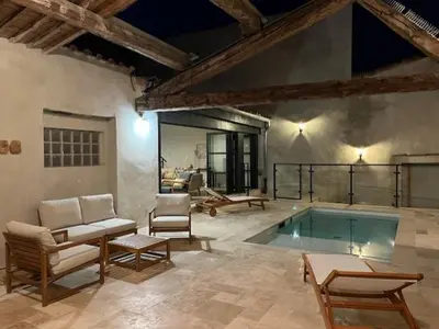 a room with a swimming pool with chairs and a table at Hidden Oasis - Maison de caractère avec piscine in Azille