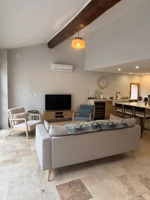 a living room with a couch and a tv at Hidden Oasis - Maison de caractère avec piscine in Azille