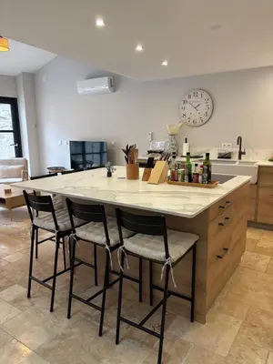 a kitchen with a large island with bar chairs at Hidden Oasis - Maison de caractère avec piscine in Azille