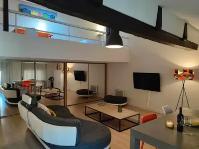 a living room with a couch and chairs and a tv at Charme de Victor ConciergerieDameCarcas in Carcassonne