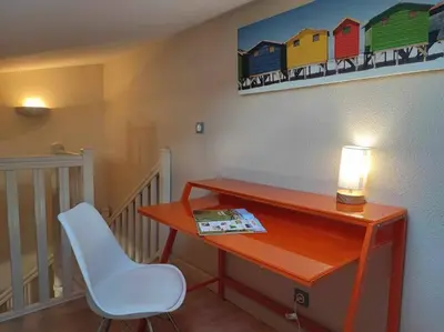 a desk with a lamp and a chair in a room at Charme de Victor ConciergerieDameCarcas in Carcassonne