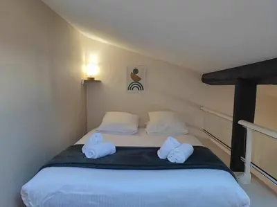 a bedroom with a bed with two towels on it at Charme de Victor ConciergerieDameCarcas in Carcassonne