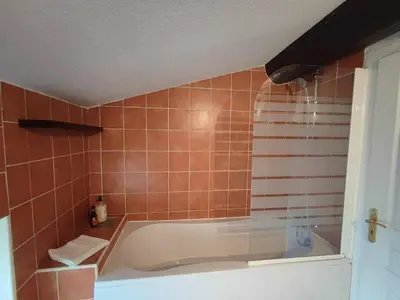 a bath tub in a bathroom with orange tile at Charme de Victor ConciergerieDameCarcas in Carcassonne