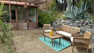 a patio with two chairs and a couch and a table at Chambre Ginkgo au Domaine de l'Aven in Villeneuve-Minervois