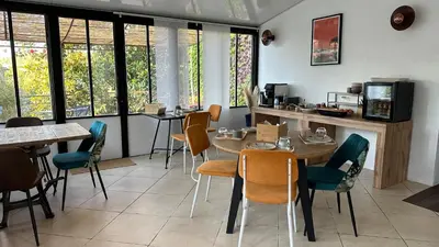 a dining room with tables and chairs and windows at Chambre Ginkgo au Domaine de l'Aven in Villeneuve-Minervois