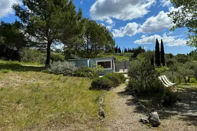 a house in the middle of a field with trees at Chambre Ginkgo au Domaine de l'Aven in Villeneuve-Minervois
