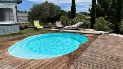 a pool on a wooden deck with chairs and a table at Chambre Ginkgo au Domaine de l'Aven in Villeneuve-Minervois