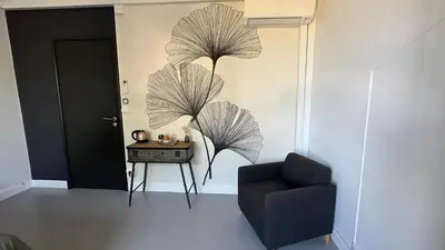 a living room with a chair and a table at Chambre Ginkgo au Domaine de l'Aven in Villeneuve-Minervois