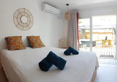 a bedroom with a bed with blue pillows on it at L'Entre Nous à Carcassonne in Carcassonne