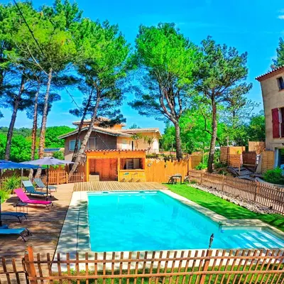 a swimming pool in a yard next to a house at L'Entre Nous à Carcassonne in Carcassonne