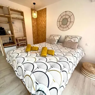 a bedroom with a large bed with yellow pillows at L'Entre Nous à Carcassonne in Carcassonne