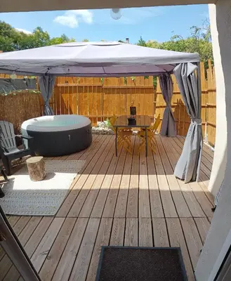 a large umbrella on a deck with a table at L'Entre Nous à Carcassonne in Carcassonne