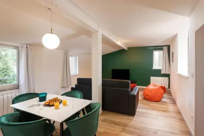 a living room with a table and green chairs at Le T2 Chic ! in Carcassonne