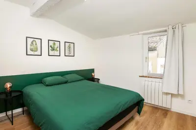 a bedroom with a green bed and a window at Le T2 Chic ! in Carcassonne