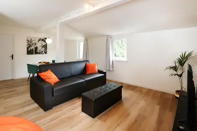 a living room with a black couch and orange pillows at Le T2 Chic ! in Carcassonne