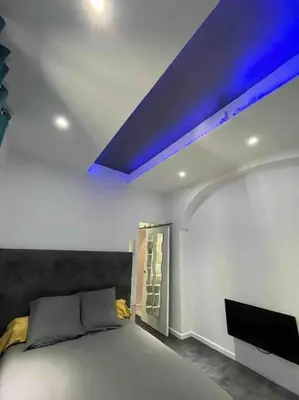 a bedroom with a bed and a blue ceiling at Les Suites du Palais in Carcassonne