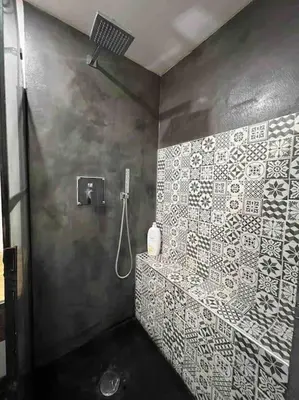 a bathroom with a shower with white tiles on the wall at Les Suites du Palais in Carcassonne