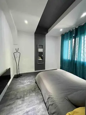 a bedroom with a large bed and blue curtains at Les Suites du Palais in Carcassonne