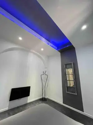 a living room with a blue ceiling and a tv at Les Suites du Palais in Carcassonne