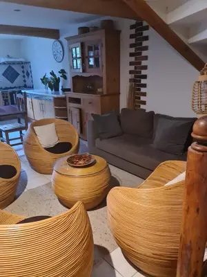 a living room with a couch and chairs and a table at Gîte à la ferme in La Tour-du-Crieu