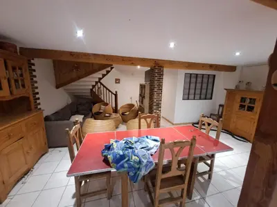 a dining room with a red table and chairs at Gîte à la ferme in La Tour-du-Crieu