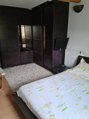 a bedroom with a bed with a wooden headboard at Gîte à la ferme in La Tour-du-Crieu