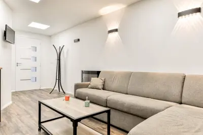 a living room with a couch and a table at Côté Palais avec Climatisation - Fibre & Netflix - Spacieux en rez-de-chaussée in Carcassonne