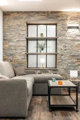 a living room with a couch and a brick wall at Côté Palais avec Climatisation - Fibre & Netflix - Spacieux en rez-de-chaussée in Carcassonne