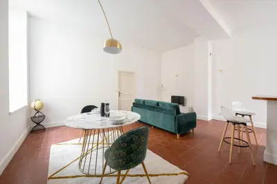 a living room with a couch and a table and chairs at superbe appartement avec cour dans la bastide in Carcassonne