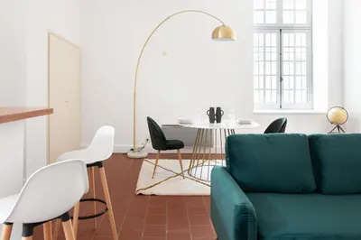 a living room with a green couch and a table at superbe appartement avec cour dans la bastide in Carcassonne