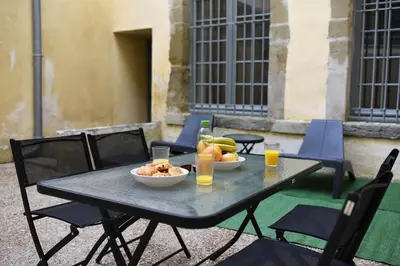 a table with a bowl of fruit and two glasses of orange juice at superbe appartement avec cour dans la bastide in Carcassonne