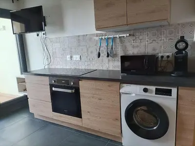 a kitchen with a washing machine and a microwave at Le Rubis in Gruissan