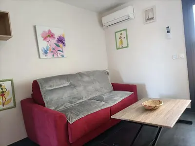 a living room with a red couch and a table at Le Rubis in Gruissan