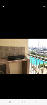 a kitchen counter with a balcony with a view of a harbor at Le Rubis in Gruissan