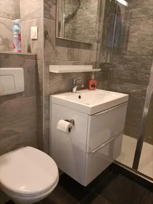 a bathroom with a white toilet and a sink at Le Rubis in Gruissan