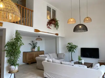 a living room with white furniture and potted plants at Maison indépendante, canal du Midi, Piscine in Homps