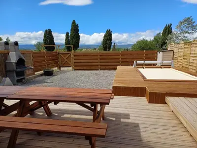 a patio with two wooden benches and a grill at Maison indépendante, canal du Midi, Piscine in Homps