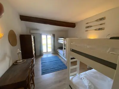 a room with bunk beds and a table and a desk at Maison indépendante, canal du Midi, Piscine in Homps