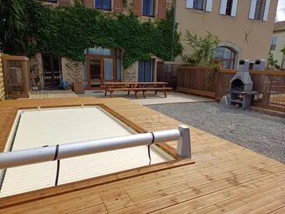 a patio with a fire pit and a wooden deck at Maison indépendante, canal du Midi, Piscine in Homps