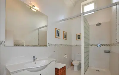 a bathroom with a sink and a toilet and a mirror at Amazing Home In Thézan-Des-Corbières in Thézan-des-Corbières