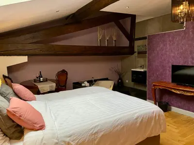 a bedroom with a large white bed and a fireplace at Pax et Amor Chambres d'hôtes de charme - Charming B&B in Mazerolles-du-Razès