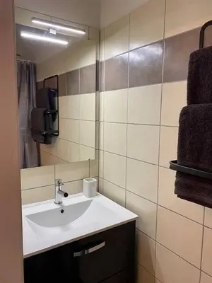 a bathroom with a white sink and a mirror at Accueillant petit T2 cœur de centre ville in Lézignan-Corbières