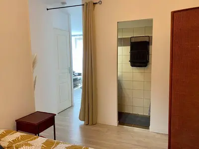 a bedroom with a shower and a bed and a mirror at Accueillant petit T2 cœur de centre ville in Lézignan-Corbières
