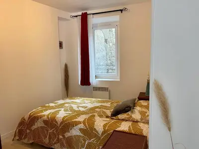 a bedroom with a bed and a window at Accueillant petit T2 cœur de centre ville in Lézignan-Corbières