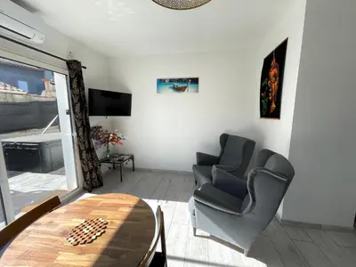 a living room with two chairs and a table at Siam Mahanakhon Appart & Spa in Rieux-de-Pelleport