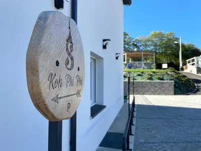 a wooden sign on the side of a building at Siam Mahanakhon Appart & Spa in Rieux-de-Pelleport
