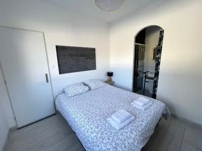 a bedroom with a bed with two towels on it at Siam Mahanakhon Appart & Spa in Rieux-de-Pelleport