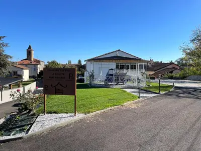 a sign on the side of a road with a house at Siam Mahanakhon Appart & Spa in Rieux-de-Pelleport